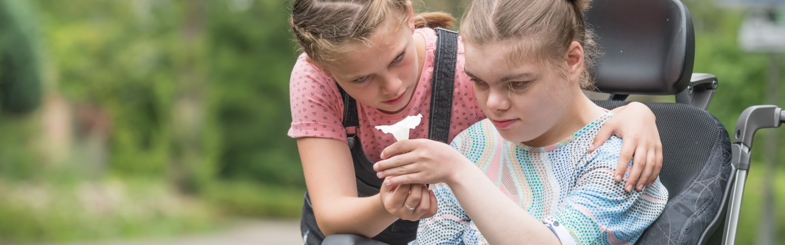 Schwester hilft der Schwester mit einer motorischen Behinderung